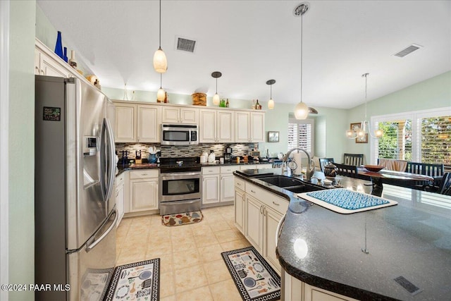 kitchen with sink, hanging light fixtures, tasteful backsplash, lofted ceiling, and appliances with stainless steel finishes