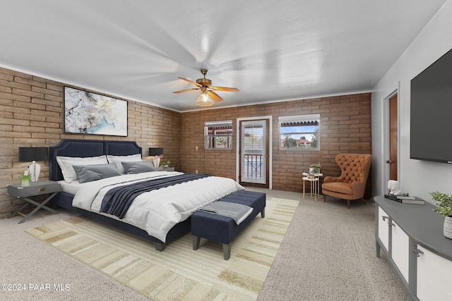 carpeted bedroom featuring access to outside, ceiling fan, and brick wall