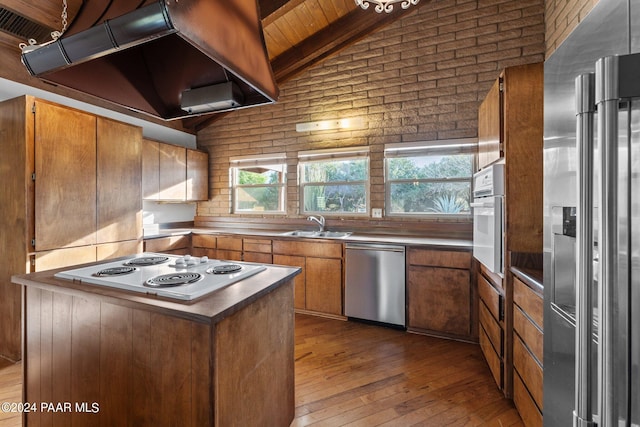 kitchen with appliances with stainless steel finishes, premium range hood, wood ceiling, lofted ceiling with beams, and hardwood / wood-style floors