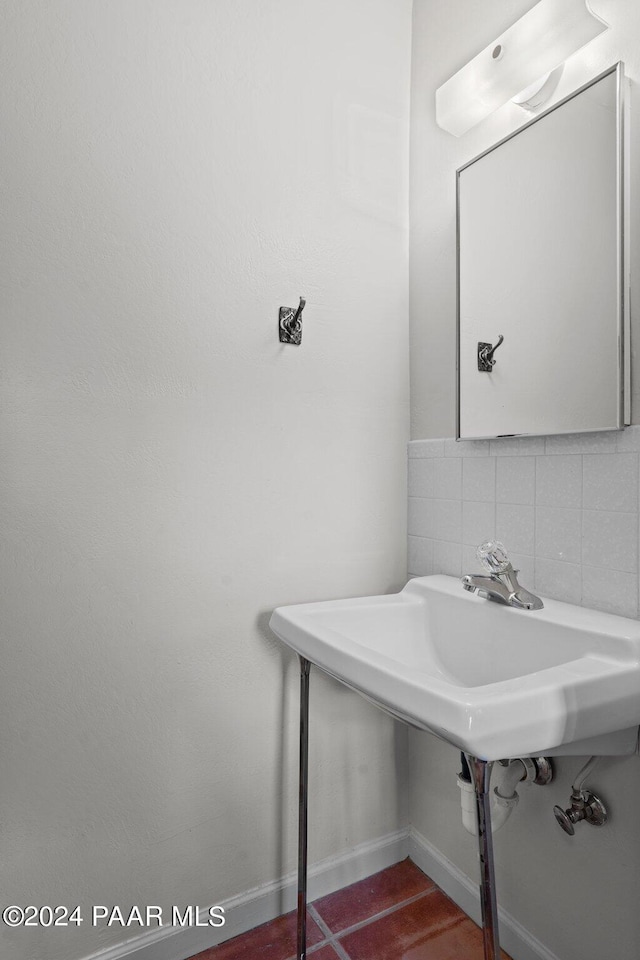 bathroom with tasteful backsplash and sink