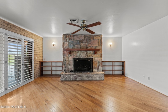 unfurnished living room with ceiling fan, light wood-type flooring, and a fireplace