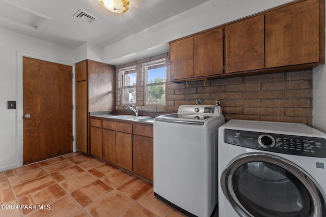 laundry room with washing machine and dryer, sink, and cabinets