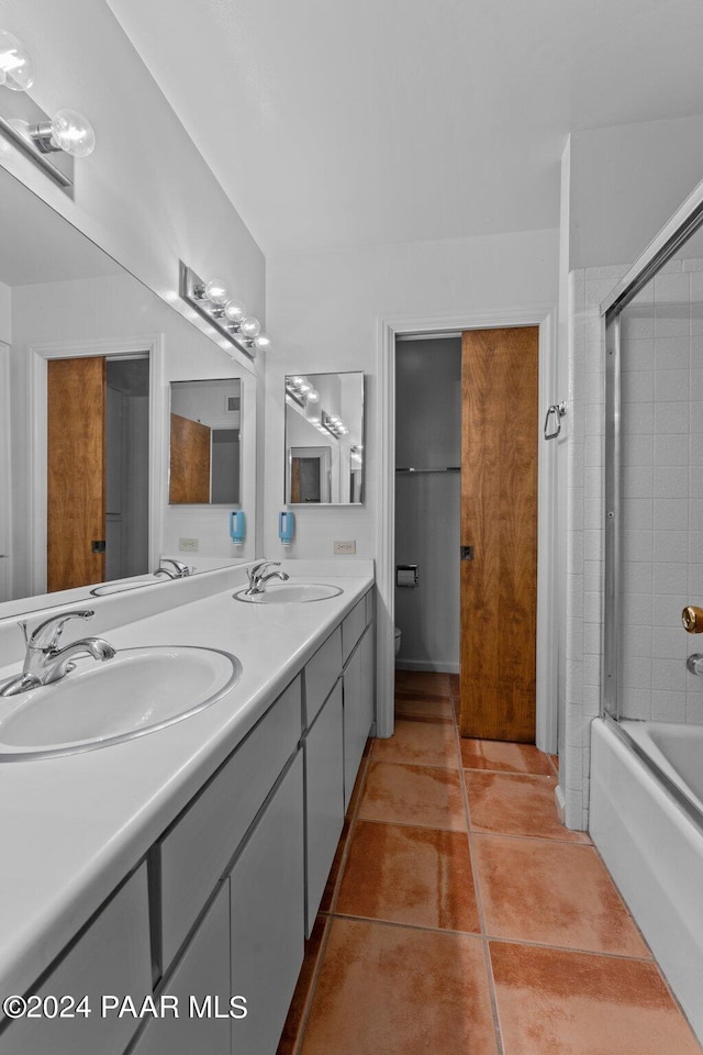 bathroom featuring tile patterned floors, vanity, and enclosed tub / shower combo