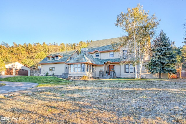 view of front of property with an outbuilding, a front yard, and a garage