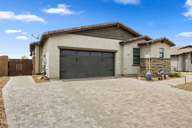 5357 Crescent Edge Dr, Prescott, AZ 86301 - view of front facade with a garage, decorative driveway, a gate, stucco siding, and a tiled roof