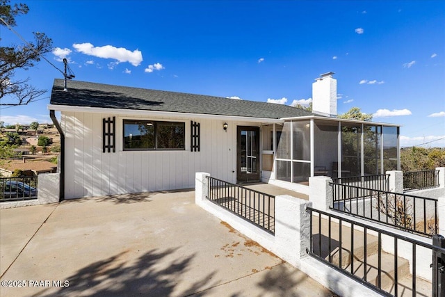 1287 N Lois Dr, Prescott, AZ 86301 - rear view of house with a sunroom, a chimney, a shingled roof, and a patio area