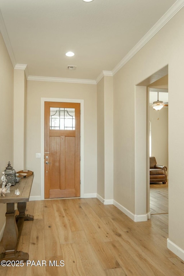 entryway with hardwood / wood-style flooring, ceiling fan, and ornamental molding