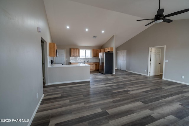 kitchen with ceiling fan, dark hardwood / wood-style floors, stainless steel refrigerator with ice dispenser, tasteful backsplash, and kitchen peninsula