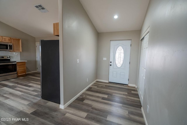 entryway with dark hardwood / wood-style flooring and vaulted ceiling