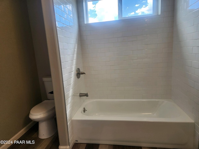 bathroom featuring tiled shower / bath and toilet