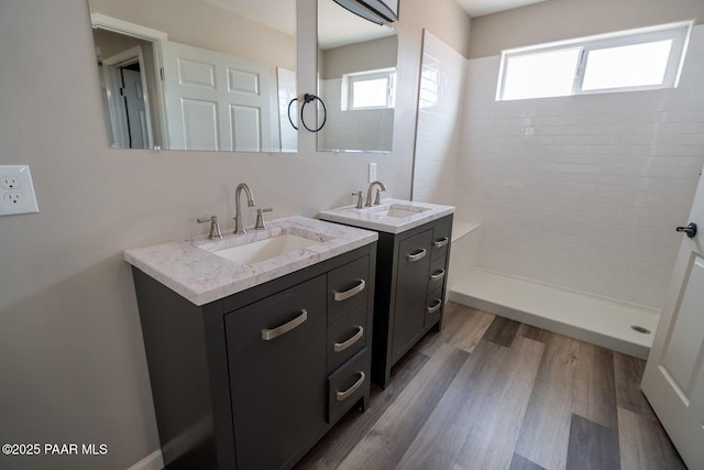 bathroom featuring vanity, hardwood / wood-style flooring, and a tile shower