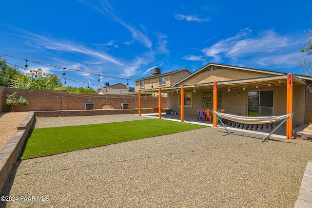 rear view of property featuring a patio and a lawn