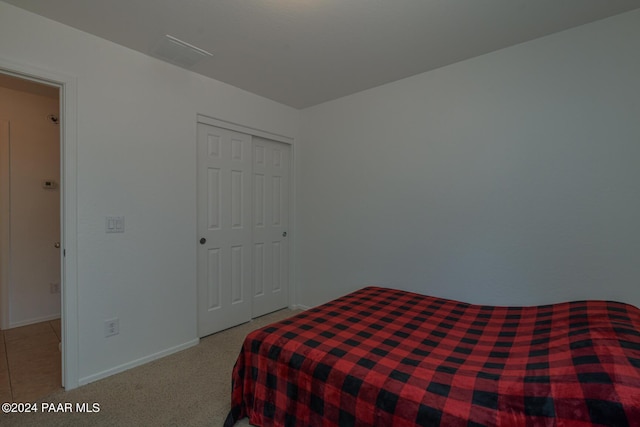 bedroom featuring light colored carpet and a closet