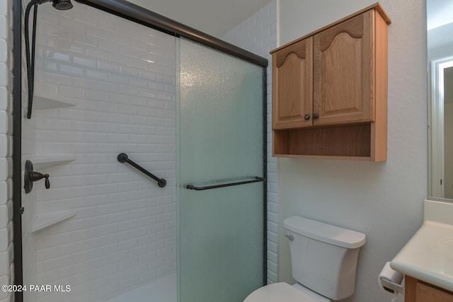 bathroom with vanity, a shower with shower door, and toilet