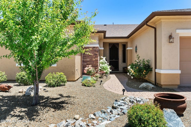 1147 N Lucky Draw Dr, Prescott Valley, AZ 86314 - view of exterior entry with stucco siding, a shingled roof, and a garage
