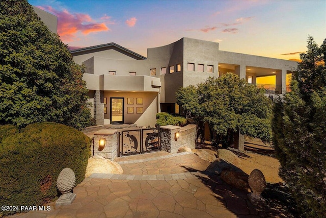 rear view of property with a patio area and stucco siding