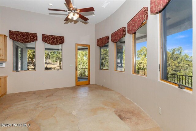 unfurnished sunroom with ceiling fan