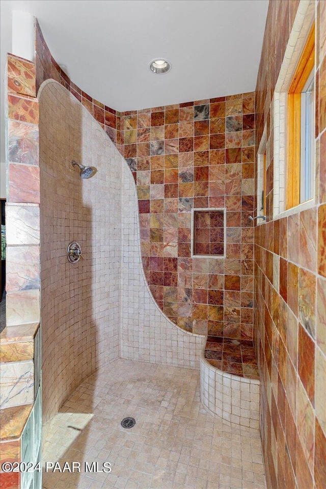 bathroom with tile patterned floors and a tile shower