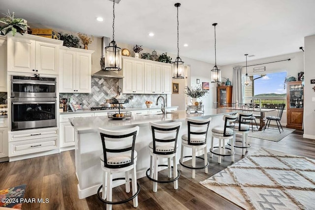 9820 N Echo Ridge Cir, Prescott Valley, AZ 86315 - kitchen with light countertops, backsplash, appliances with stainless steel finishes, a sink, and wall chimney range hood
