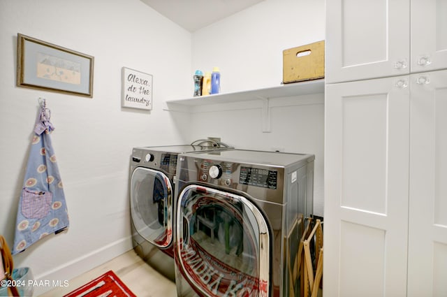 laundry room with washer and dryer and cabinets