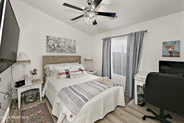 bedroom featuring hardwood / wood-style flooring, vaulted ceiling, and ceiling fan