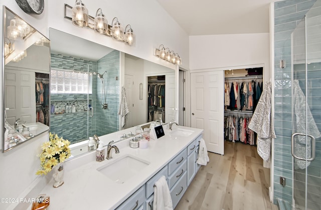 bathroom featuring lofted ceiling, hardwood / wood-style floors, vanity, and an enclosed shower