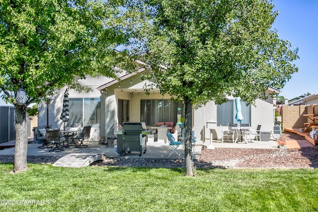 back of house with a lawn and a patio area