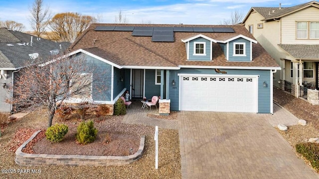 view of front of house featuring solar panels and a garage