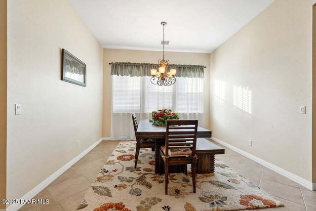 tiled dining space with an inviting chandelier