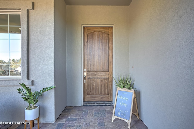 entrance to property featuring stucco siding