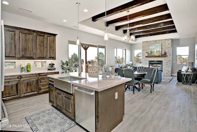 kitchen featuring recessed lighting, light wood-style flooring, beamed ceiling, dishwasher, and a sink