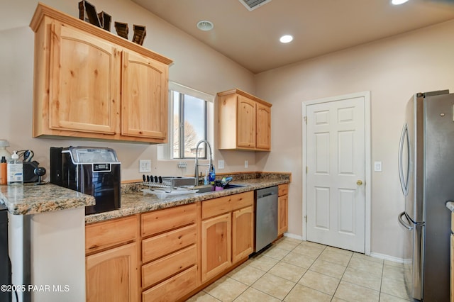 kitchen featuring light brown cabinetry, stainless steel appliances, sink, stone counters, and light tile patterned flooring