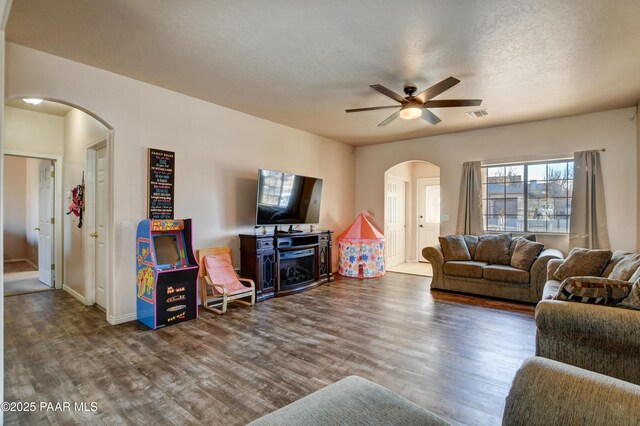 living room featuring ceiling fan, a textured ceiling, and hardwood / wood-style flooring