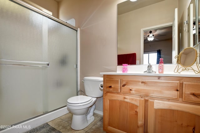 bathroom featuring vanity, a shower with door, tile patterned floors, ceiling fan, and toilet