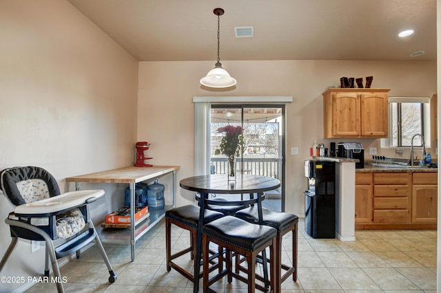 kitchen with light tile patterned floors, hanging light fixtures, a healthy amount of sunlight, and sink