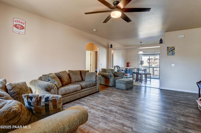 living room with ceiling fan and dark wood-type flooring