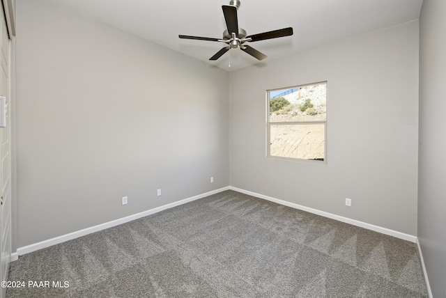 unfurnished room with dark colored carpet, baseboards, and ceiling fan