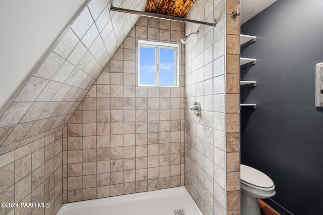 bathroom featuring tiled shower and toilet