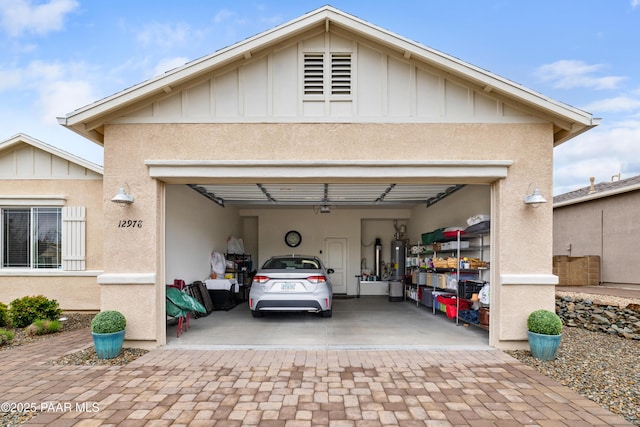 view of front of home with board and batten siding, decorative driveway, stucco siding, and an attached garage
