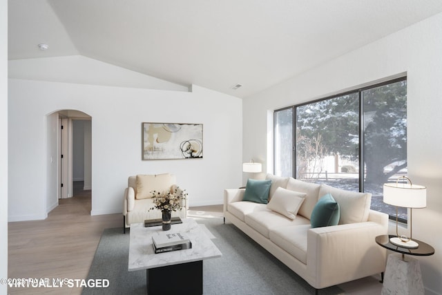 living room featuring vaulted ceiling and light wood-type flooring