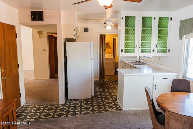 kitchen featuring a sink, visible vents, ceiling fan, and freestanding refrigerator