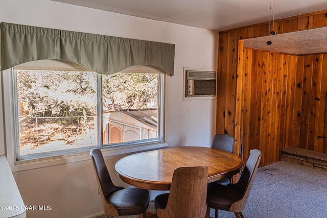 carpeted dining room with wood walls and an AC wall unit