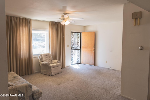 sitting room with a ceiling fan and carpet floors