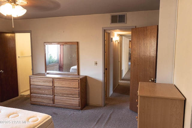 bedroom with visible vents and dark carpet