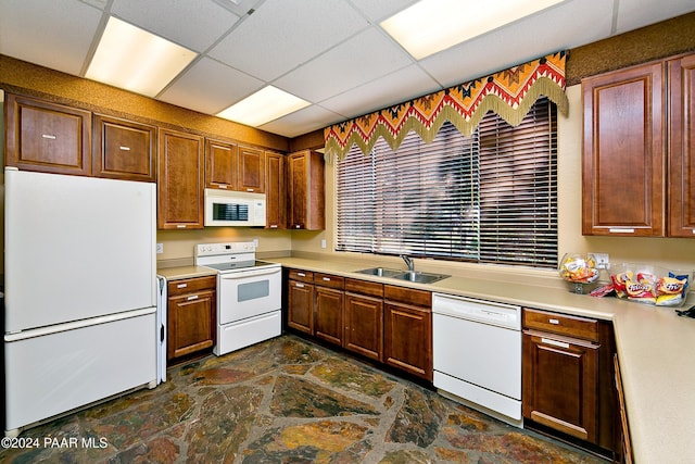 kitchen featuring white appliances, a drop ceiling, and sink