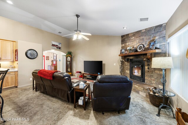 living room with ceiling fan and a stone fireplace