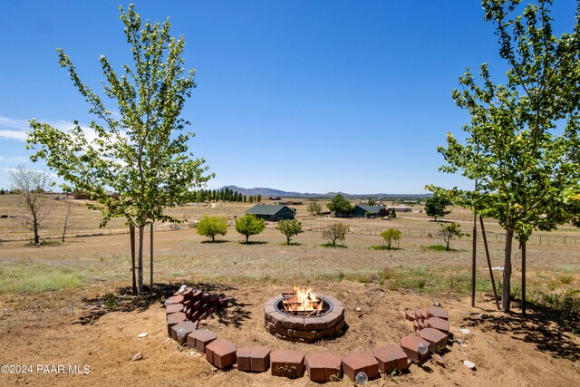 view of yard with a mountain view, a rural view, and a fire pit