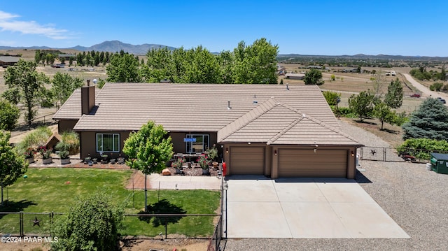 view of front of property with a mountain view, a garage, and a front lawn