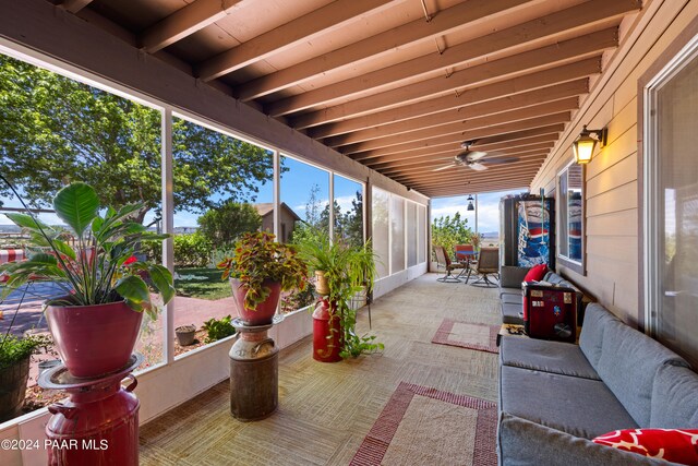 sunroom / solarium featuring a healthy amount of sunlight and beam ceiling