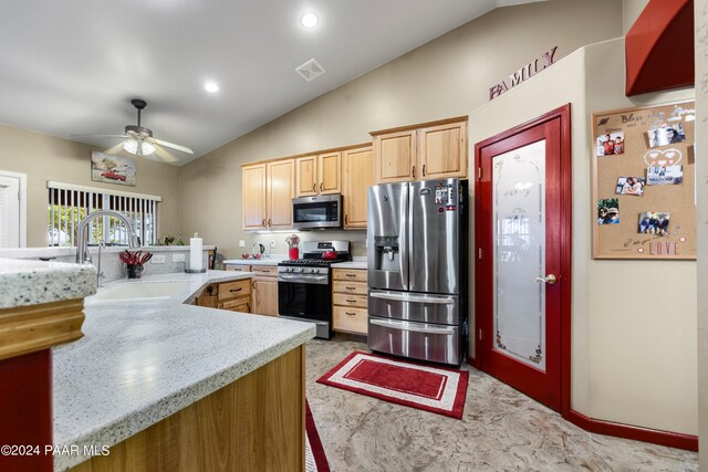 kitchen featuring ceiling fan, sink, stainless steel appliances, vaulted ceiling, and light brown cabinetry